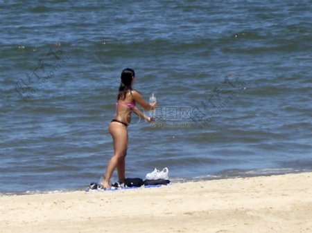 沙滩上装水的女人