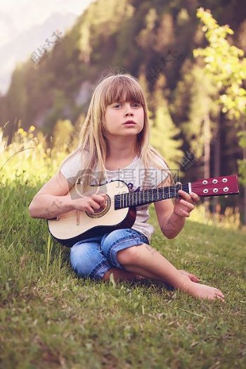 在草地上弹吉他的女孩