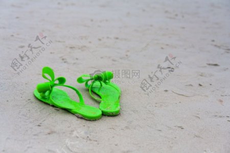 沙滩上的绿色拖鞋